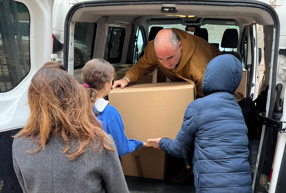 Profesionales y personas jóvenes atendidas por Diagrama descargan una de las 3 furgonetas llenas de donaciones