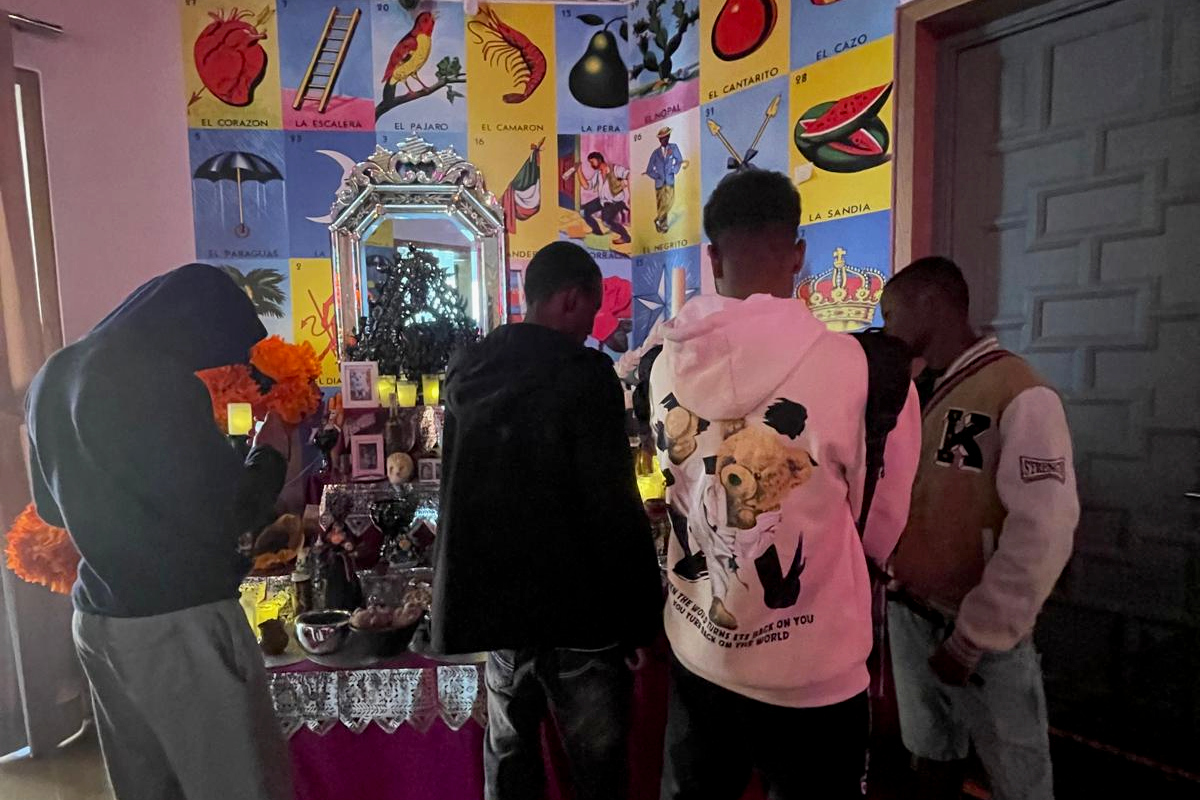 Cuatro de los jóvenes observan el altar instalado en la Casa de México