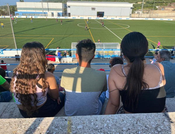 Dos chicas y un chico del centro Anassim en la grada viendo el partido entre veteranos del Levante UD y el Moixent