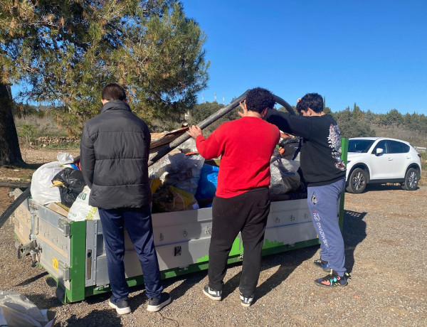 Los tres jóvenes tiran la basura recogida al contenedor habilitado