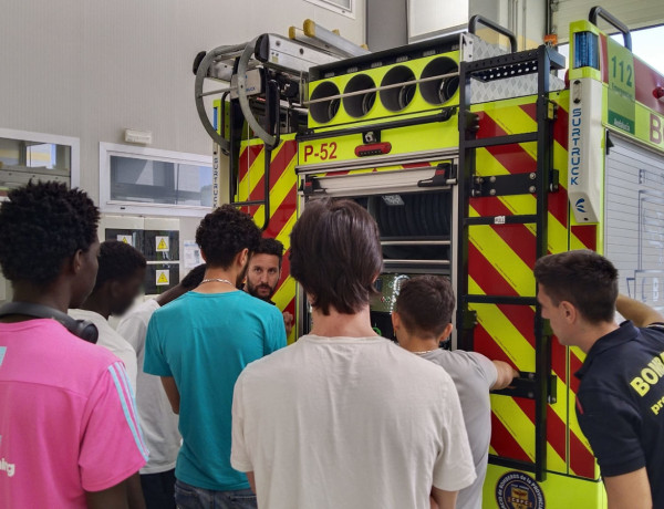 Dos bomberos les explican a los jóvenes cómo funciona el camión que utilizan