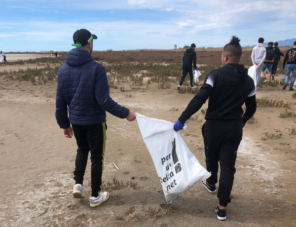 Dos jóvenes del centro, con una bolsa medio llena de los residuos que han ido recogiendo