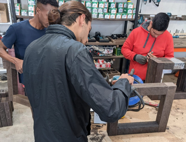 El joven de La Villa, de espaldas, aprende a fabricar una pieza de madera en el taller de la Asociación AMIF-Integrados 