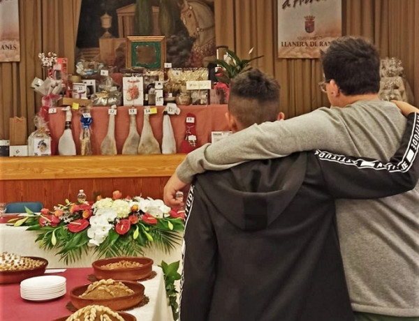 Un joven y un educador, junto a la mesa con los distintos arnadís del concurso