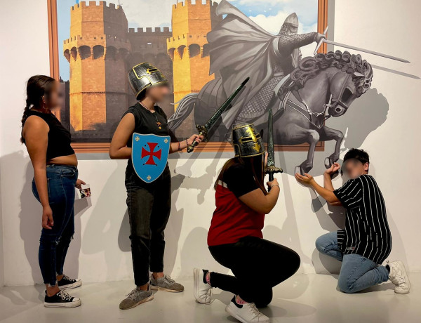 Cuatro jóvenes posan con una de las obras del museo