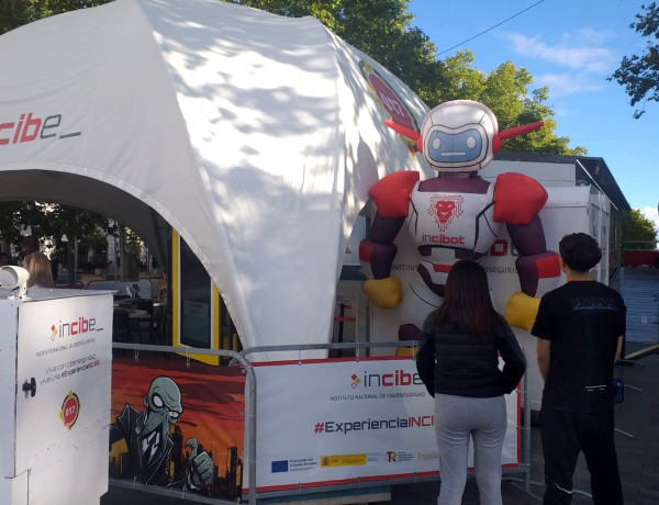 Dos jóvenes contemplan la carpa de Incibe