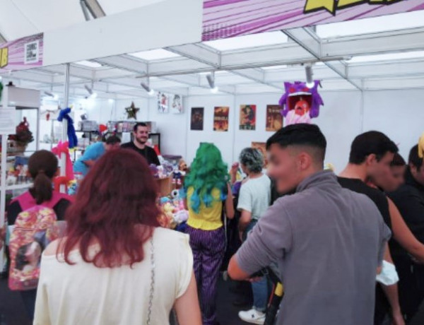 Un grupo de gente visita uno de los puestos de la feria