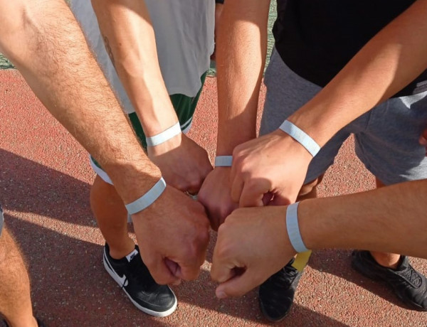 Manos de los jóvenes mostrando la pulsera de voluntario