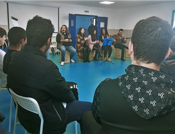 Pepe el Marismeño, junto al grupo de intérpretes que le acompaña, habla con los jóvenes de Odiel