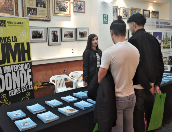 Dos jóvenes en la mesa de la UMH en la VI Feria de Orientación Educativa y Laboral ‘Orienta-t’ de Petrer