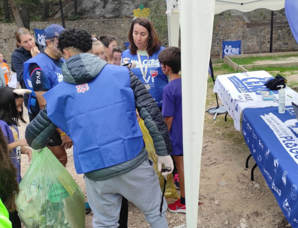 Un joven del centro recoge una de las bolsas de basura entregadas por niños y niñas de Villena