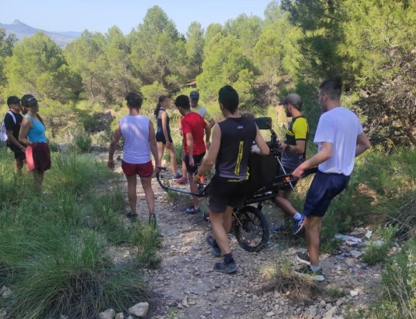 Los jóvenes ayudan a la usuaria a realizar la ruta