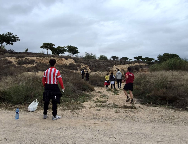 Un joven se acerca a un tramo de ruta para ofrecer agua a los corredores