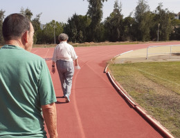 Dos personas mayores del centro participan en los '1.000 pasos por la salud' en una pista de atletismo