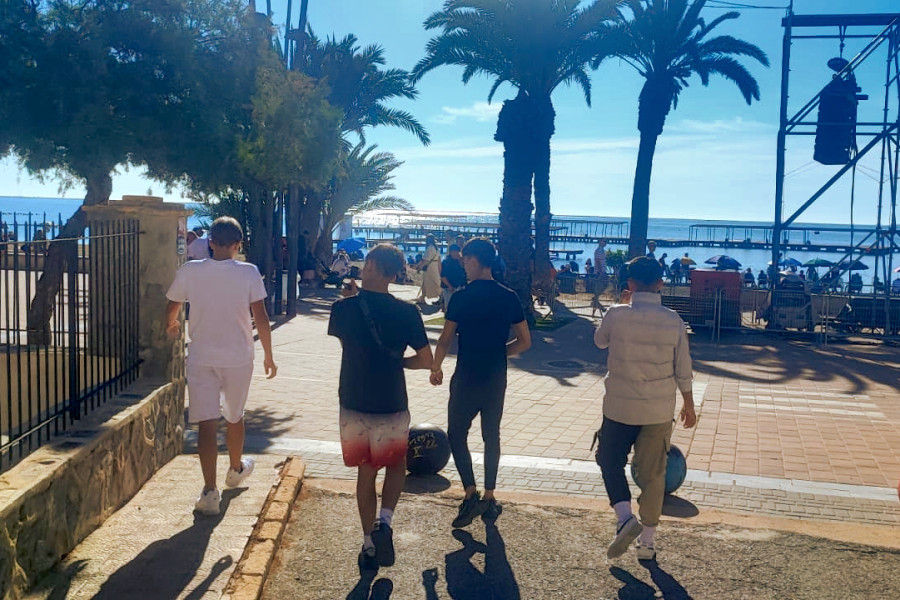 Cuatro de los jóvenes asistentes recorren el paseo de Santiago de la Ribera para asistir al espectáculo aéreo