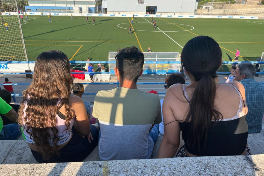 Dos chicas y un chico del centro Anassim en la grada viendo el partido entre veteranos del Levante UD y el Moixent