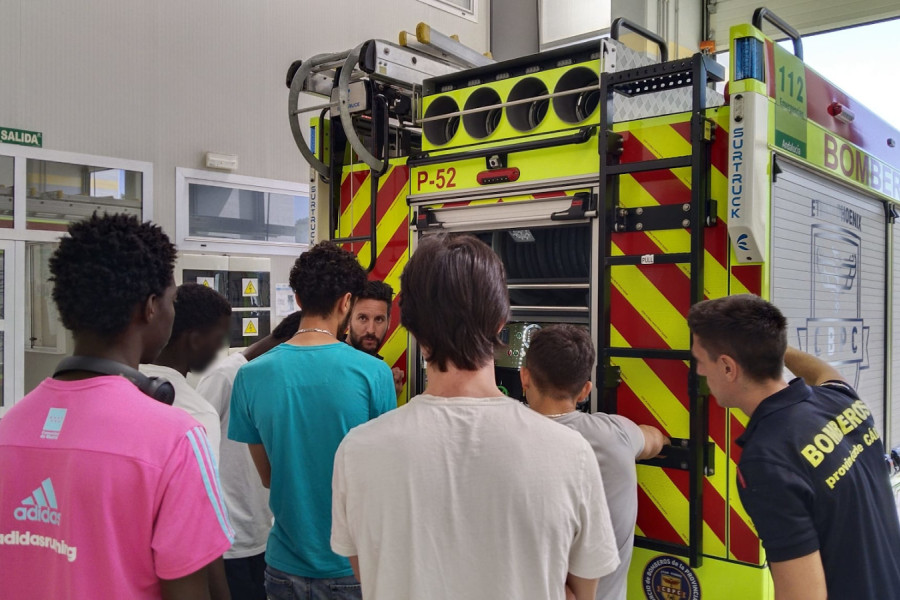 Dos bomberos les explican a los jóvenes cómo funciona el camión que utilizan