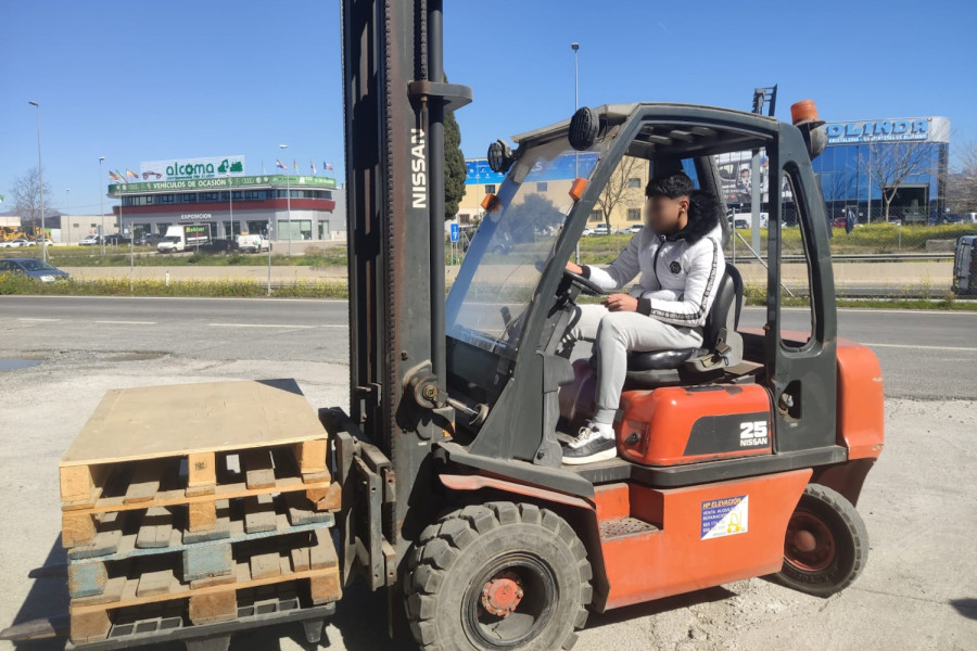 Un joven realiza unas prácticas con una carretilla elevadora