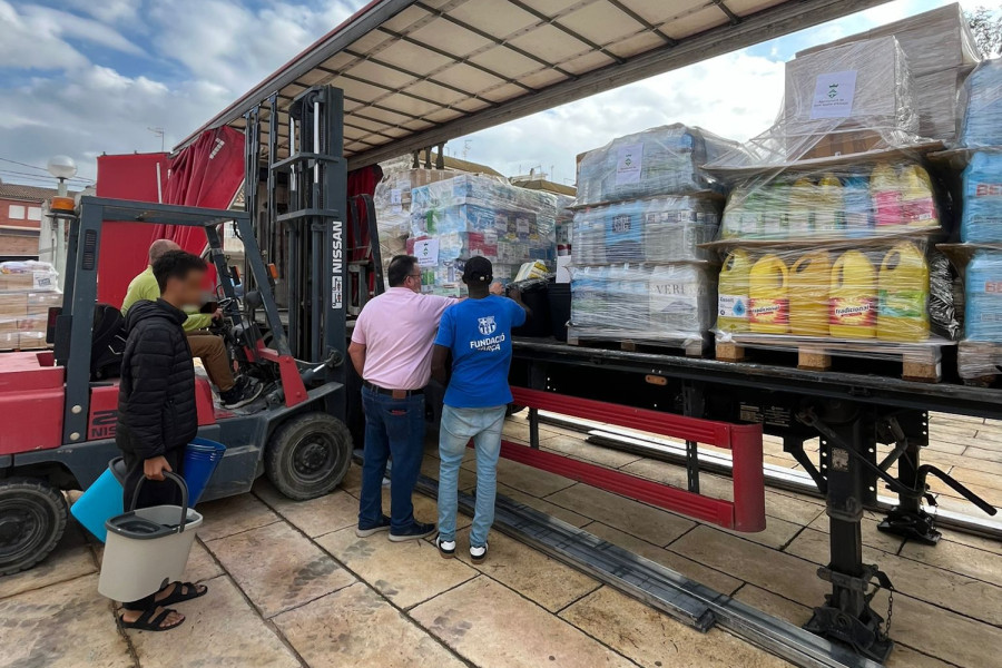 Los dos jóvenes ayudan a otros voluntarios a llenar el camión