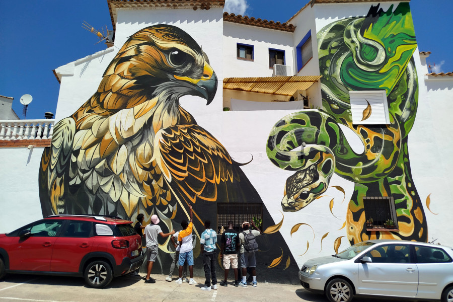 Los jóvenes observan uno de los murales de la localidad
