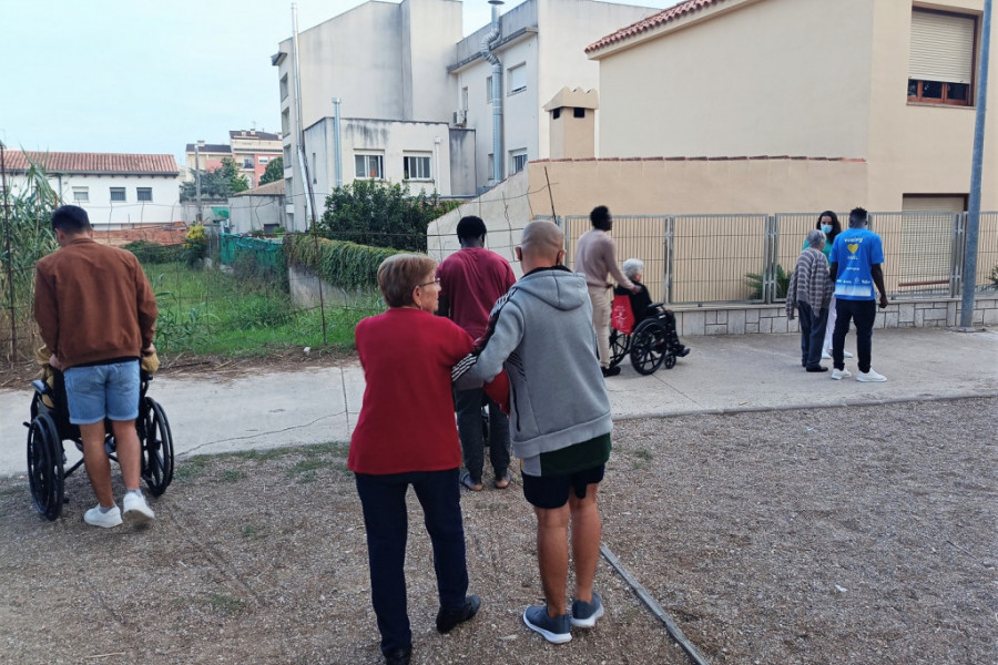 Varios jóvenes acompañan a personas mayores de la residencia en un paseo por Ulldecona