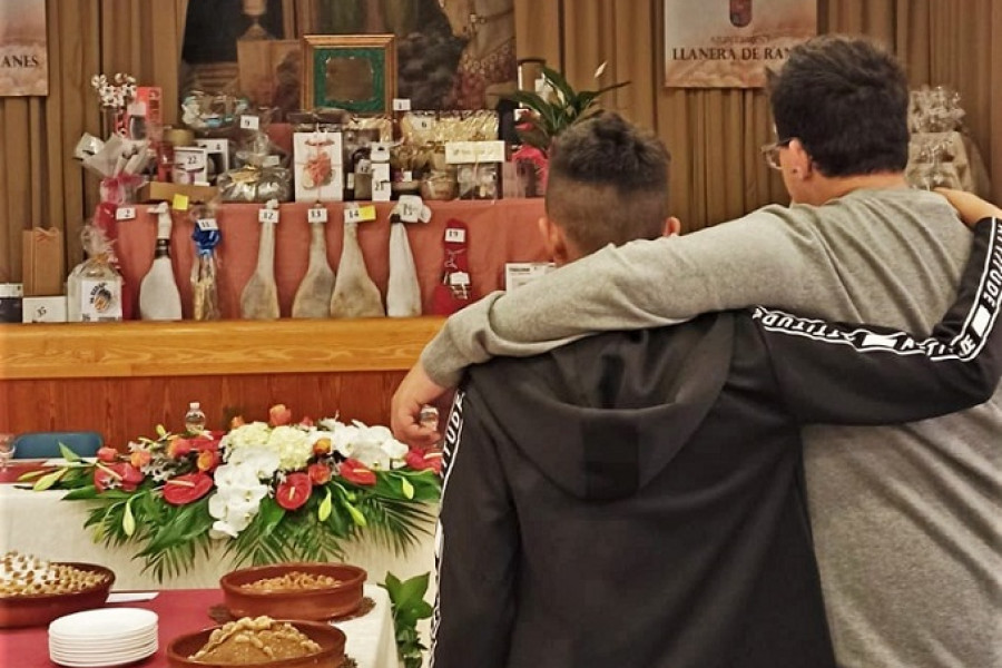 Un joven y un educador, junto a la mesa con los distintos arnadís del concurso