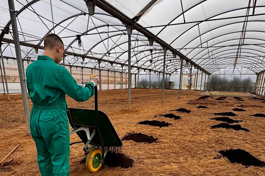 Uno de los jóvenes prepara el terreno del invernadero del centro