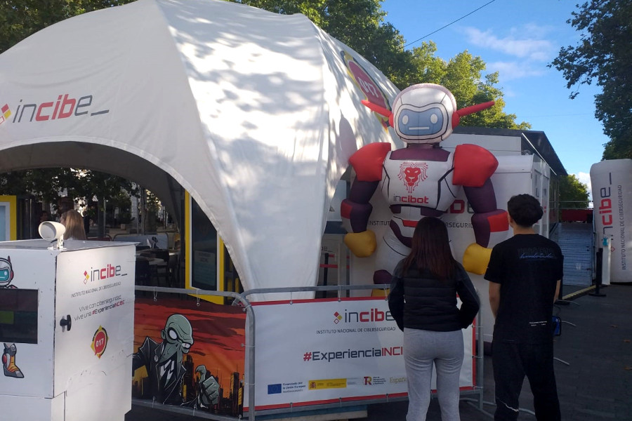 Dos jóvenes contemplan la carpa de Incibe