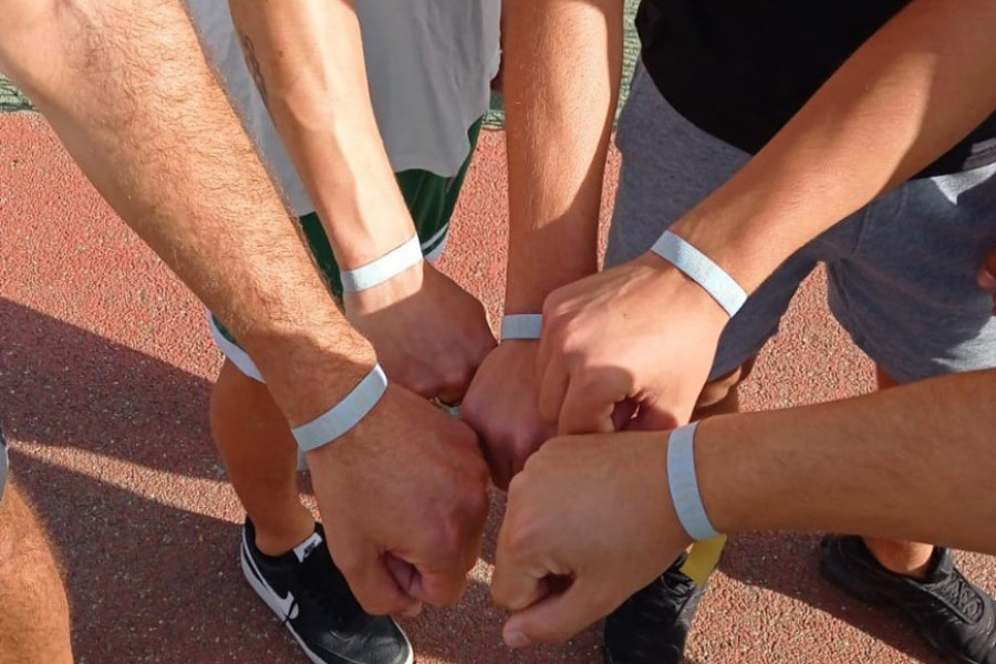 Manos de los jóvenes mostrando la pulsera de voluntario