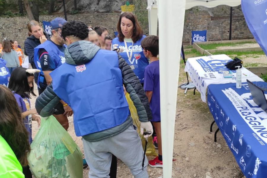 Un joven del centro recoge una de las bolsas de basura entregadas por niños y niñas de Villena